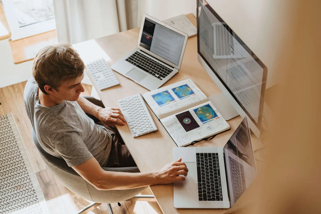 A developer working on three computers simultaneously.